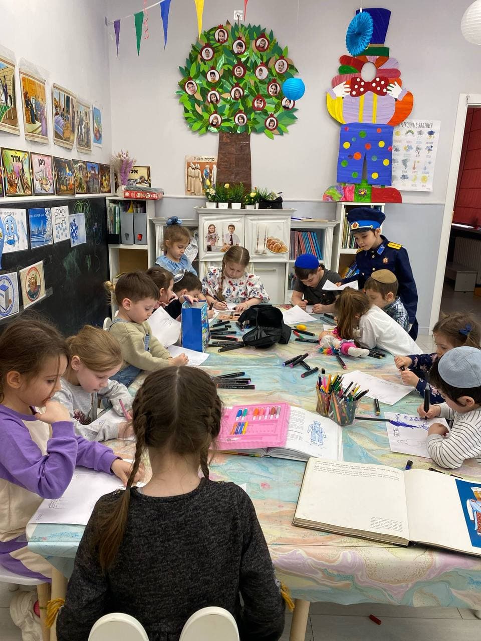 Дети рисуют и выполняют задания за общим столом